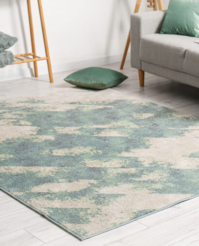 Soft stylish carpet on grey wooden floor in living room interior