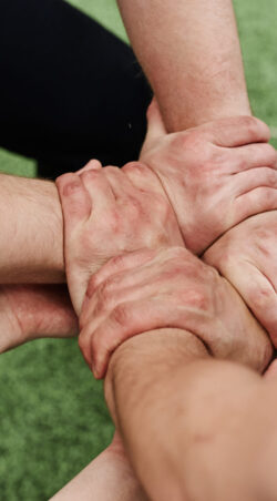 High angle view of cheerleader team holding hands and doing tricks together outdoors